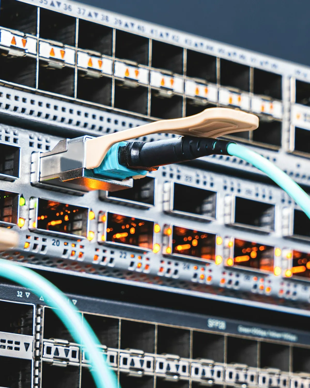 An engineer patching a redundant uplink into a live switch
